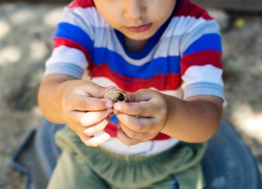 bir salyangoz bahçesinde oynayan çocuk