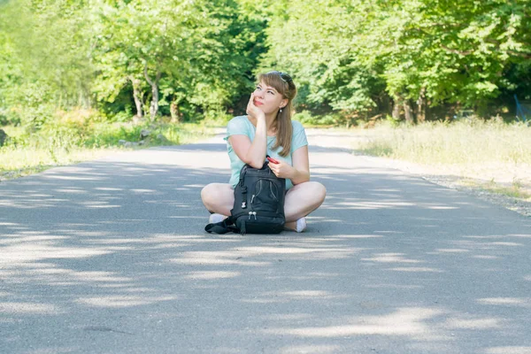 Mujer joven sentada en el camino — Foto de Stock