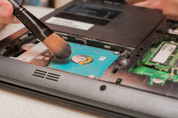 master cleans dust in laptop