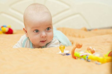 Bebeğin midesi üzerinde yatıyor ve oyuncaklar saatler