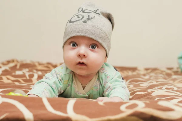 Bebê 4 meses em uma tampa levantada em suas mãos — Fotografia de Stock