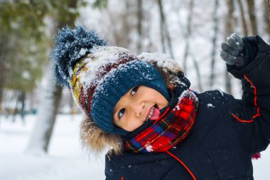 Neşeli çocuk kışın ormanda yürüyüşe çıktı.
