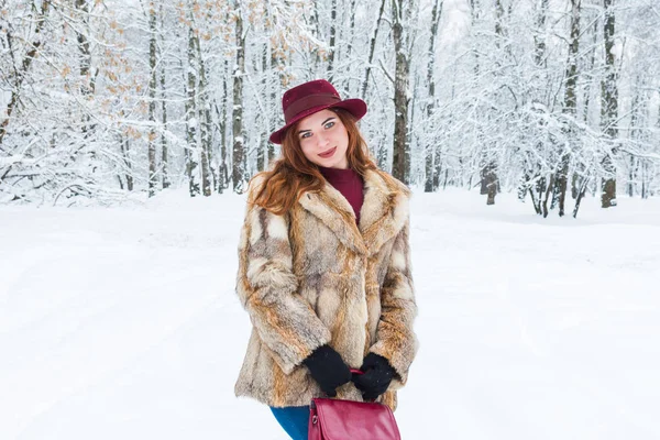 Modieuze jonge vrouw met hoed in winterbos — Stockfoto