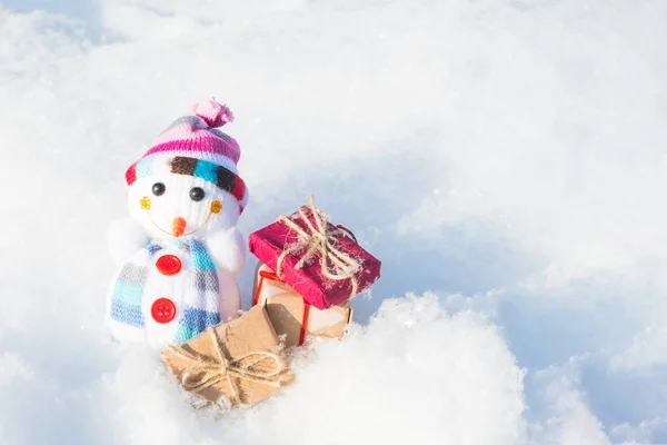 Spielzeugschneemann mit Geschenken im Schnee — Stockfoto