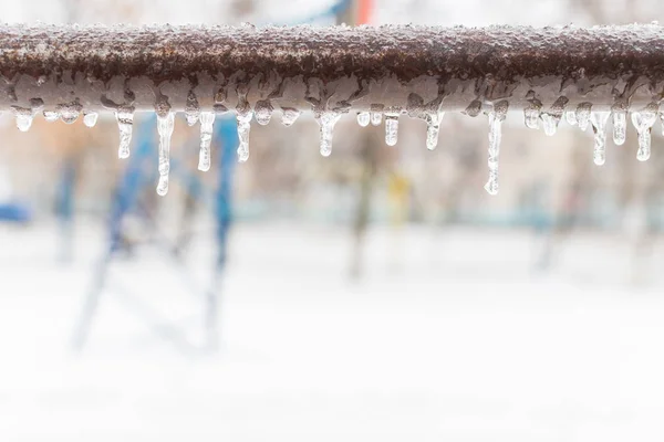 frozen icicles after rain on the pipe