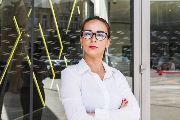 Portret van een strikte zakenvrouw in bril op de achtergrond — Stockfoto
