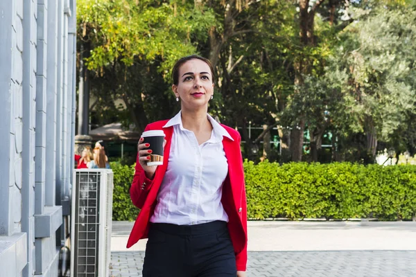 Joven mujer de negocios con café en la mano al aire libre — Foto de Stock