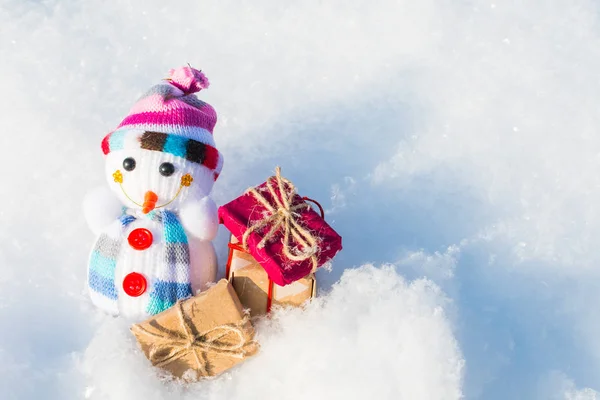 Spielzeugschneemann mit Geschenken im Schnee — Stockfoto