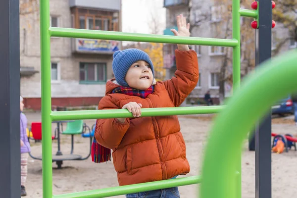 Junge spielt im Herbst auf dem Spielplatz — Stockfoto