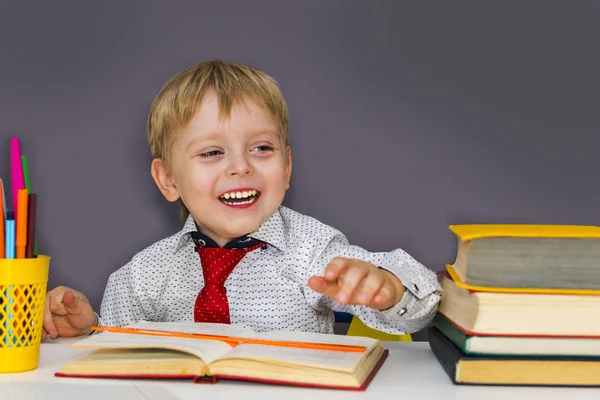 Wesoły przedszkolak z książkami na szarym tle — Zdjęcie stockowe