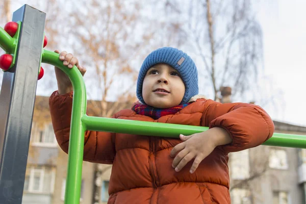 Pojke som leker på lekplatsen under hösten — Stockfoto