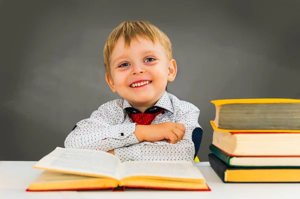 Cheerful preschooler boy on the background of the blackboard. — Stock Photo, Image