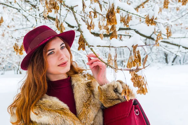 Μοντέρνα νεαρή γυναίκα στο καπέλο στο δάσος του χειμώνα — Φωτογραφία Αρχείου