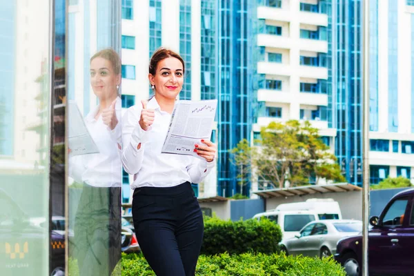 Mujer de éxito de negocios con un periódico en sus manos en la c — Foto de Stock