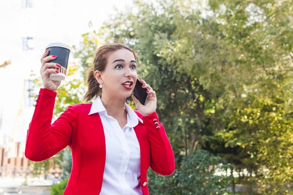 Una mujer en un traje de negocios habla emocionalmente por teléfono — Foto de Stock