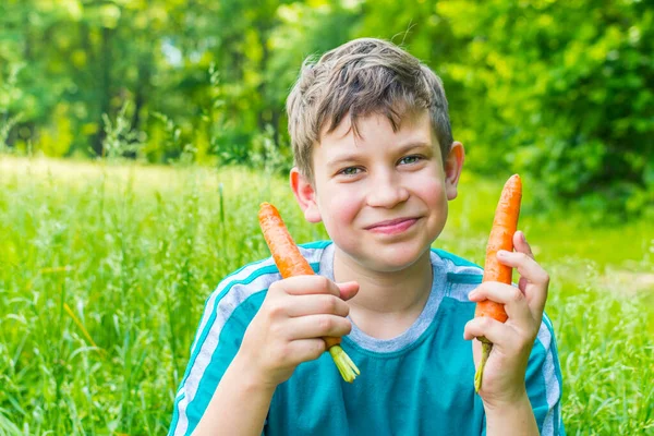 Teen Boy Con Una Carota Una Foresta Foto Stock