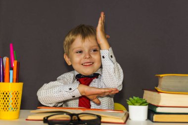 Çocuk elini uzatıyor. Anaokulu öğrencisi masada oturur.
