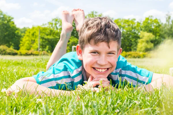 Niño Sonriente Acostado Sobre Hierba Sobre Estómago — Foto de Stock