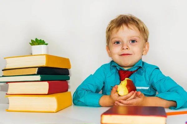 机の上の未就学児がリンゴを食べている 授業中のおやつ — ストック写真