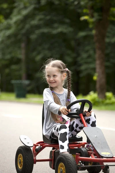 Χαμογελαστό κοριτσάκι αγωνιστικών αυτοκινήτων amusemant πάρκο — Φωτογραφία Αρχείου