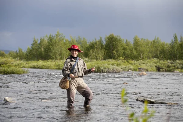 Mujer sonriente pesca con mosca — Foto de Stock