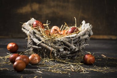 siyah ahşap bir masa üzerinde bir sepet içinde Paskalya zamanı, renkli yumurta