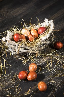 siyah ahşap bir masa üzerinde bir sepet içinde Paskalya zamanı, renkli yumurta