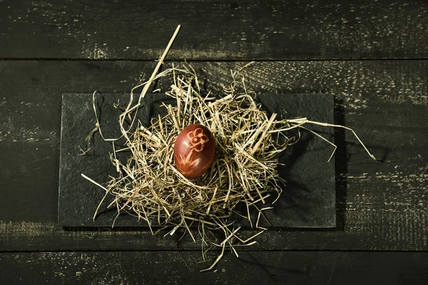 Tiempo de Pascua, un huevo de un solo color en paja —  Fotos de Stock