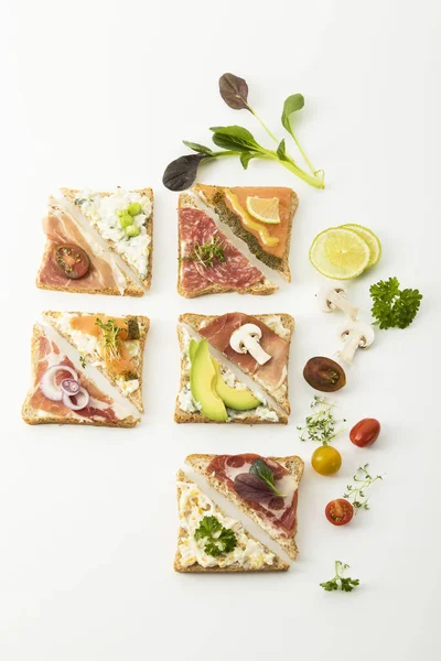 Tostadas integrales servidas con salmón, jamón, tocino y salami — Foto de Stock