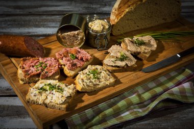 sosisi ile Alman taze kepekli ekmek, bir ahşap tahta üzerinde greaves aşırı duygusallık ve mettwurst severd