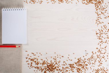 defter kalemler için tohumları ile kurulların Beyaz ahşap masa üzerine notlar ile