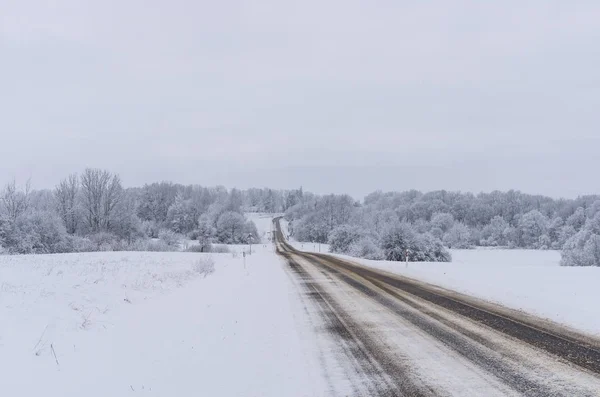 Straße bedeckt Winterschnee im Feld — Stockfoto