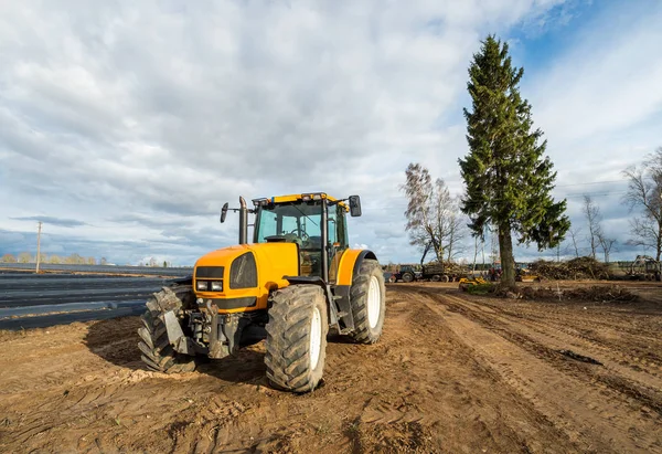 Yellow tractor stay at the field after works — Stock Photo, Image