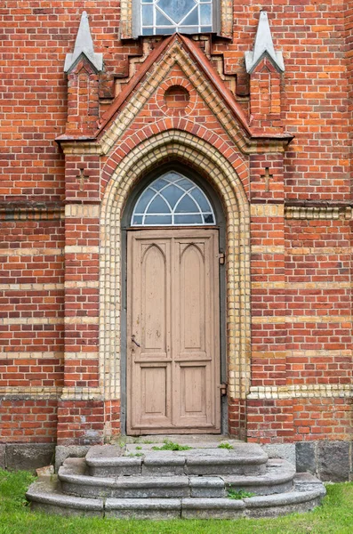 Eski kapı ve merdiven kırmızı tuğla duvar.