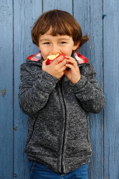 Barn barn äta äpple frukt stående format utomhus hösten — Stockfoto