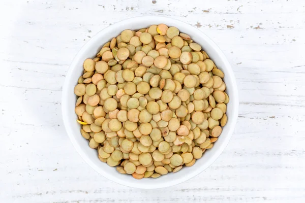 Green lentils raw from above bowl wooden board — Stock Photo, Image