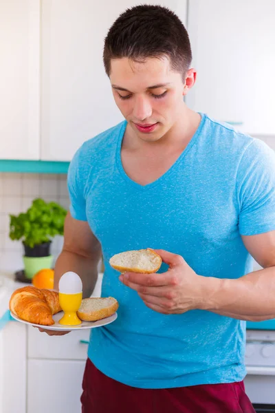 Genç adam yemek kahvaltı mutfak portre biçimi sabahları — Stok fotoğraf