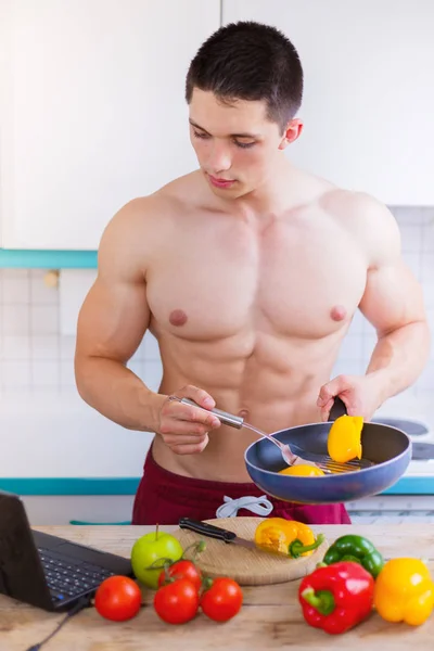 Cucina giovane uomo verdura ricetta computer formato verticale mangiare — Foto Stock