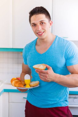 İçinde mutfak portre biçimi smilin yemek kahvaltı genç adam
