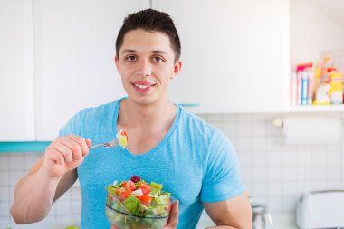 Salata genç yeme adam mutfakta sağlıklı yiyecek vegan copyspac