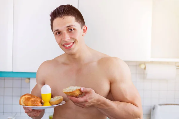 Młody mężczyzna jedzenie śniadanie w kuchni rano lato — Zdjęcie stockowe