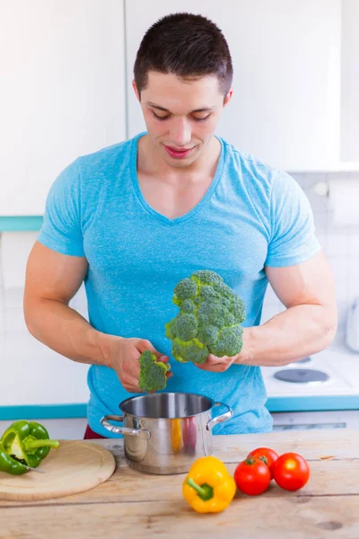 Giovane uomo cucina pasto sano verdure formato verticale nel — Foto Stock