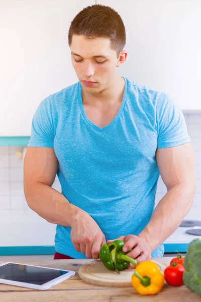 Jovem cozinhar comida saudável legumes tablet internet portra — Fotografia de Stock