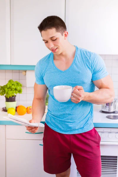 La lectura de café periódico hombre en el formato de retrato de la cocina mañana — Foto de Stock