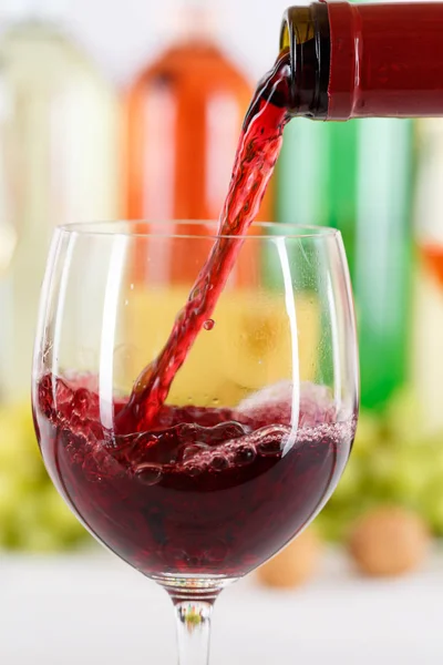 Vylévající skleněná láhev na víno červené nalít formát portrét — Stock fotografie