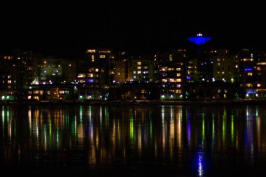 Night city with lights reflecting in river water