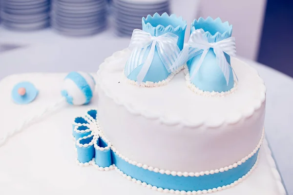 Birthday cake with children shoes on top — Stock Photo, Image