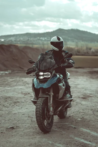 現代のバイクに乗ってヘルメットとバイクの服とモーターサイク リスト バック グラウンドで目に見える美しい山々 — ストック写真