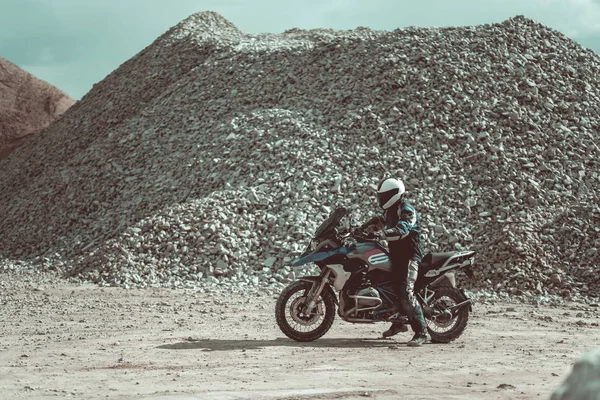 Мотоциклист Шлеме Мотоцикле Сидит Современном Мотоцикле Камни Заднем Плане — стоковое фото
