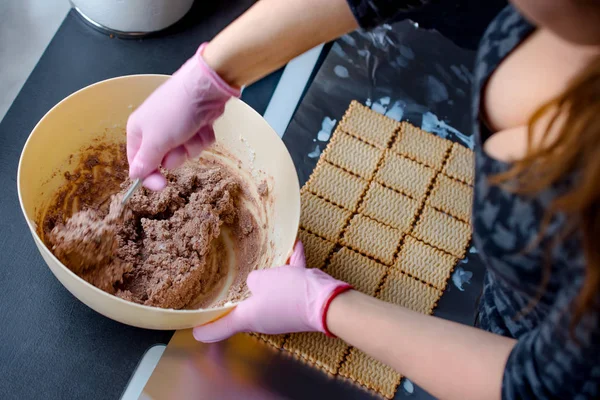 Women with pink gloves preparing homemade cake, shes mixing dough in plastic bowl